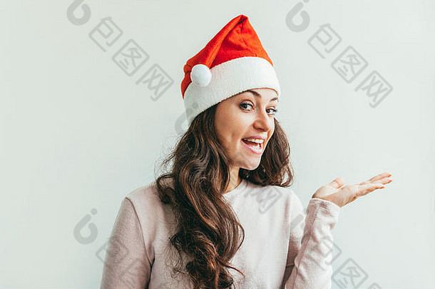 美丽的女孩长头发红色的圣诞老人老人他显示开放棕榈手孤立的白色背景年轻的女人肖像真正的情绪快乐圣诞节一年假期