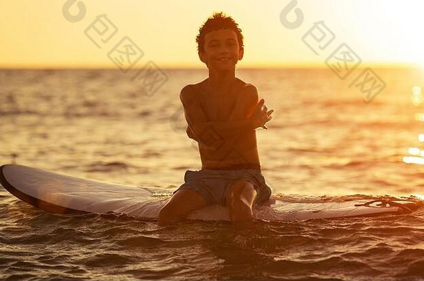 轮廓男孩冲浪板平静海享受日落