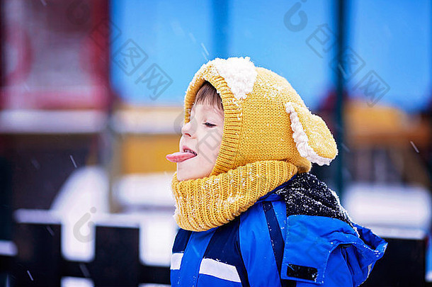可爱的男孩玩雪公园操场上冬季