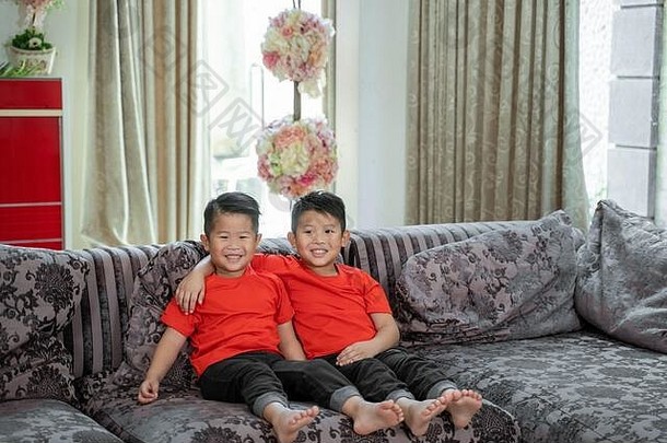亚洲男孩微笑穿红色的衬衫