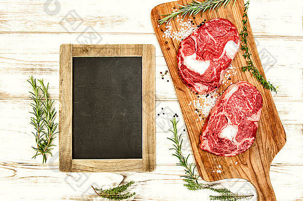 生新鲜的牛肉肉草本植物香料黑板上木桌子上食物背景古董风格健美的图片