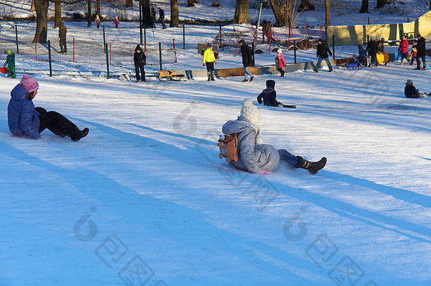 孩子们爱冬天滑雪橇下坡有趣的