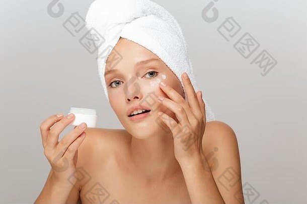 肖像年轻的沉思的女人化妆白色毛巾头应用脸奶油深思熟虑相机灰色的背景