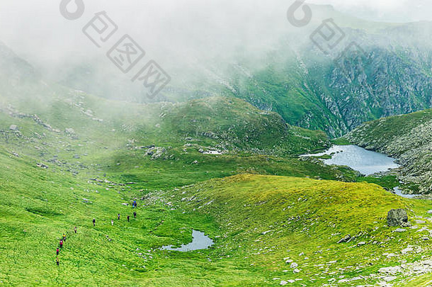 集团徒步旅行者通过多雾的谷喀尔巴阡山山