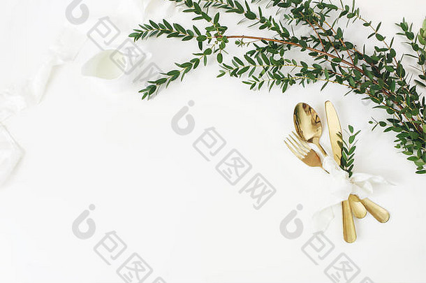 节日婚礼生日表格设置金餐具桉树parvifolia丝绸丝带牛奶投手白色表格背景乡村餐厅菜单概念平躺前视图空空间