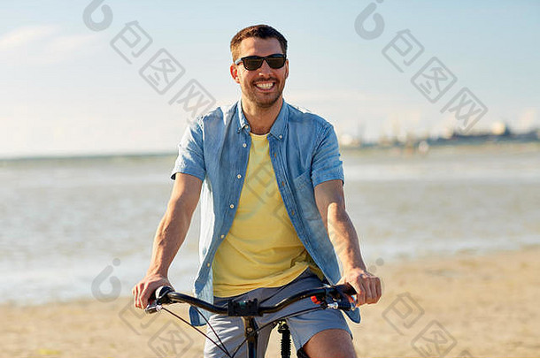 快乐男人。骑自行车夏天海滩