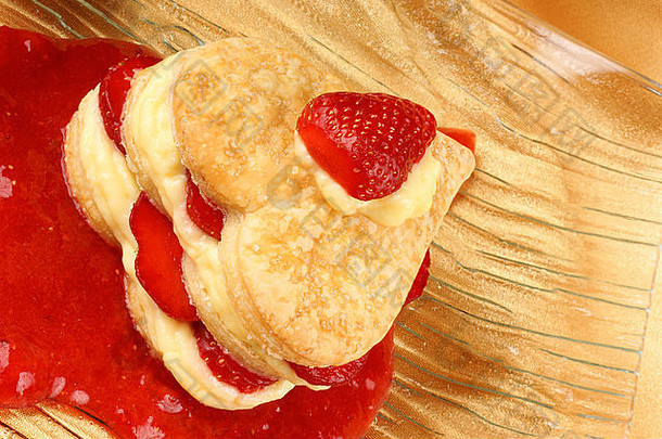 心形状的草莓蛋奶沙司millefeuille草莓酱汁黄色的背景甜蜜的情人节一天
