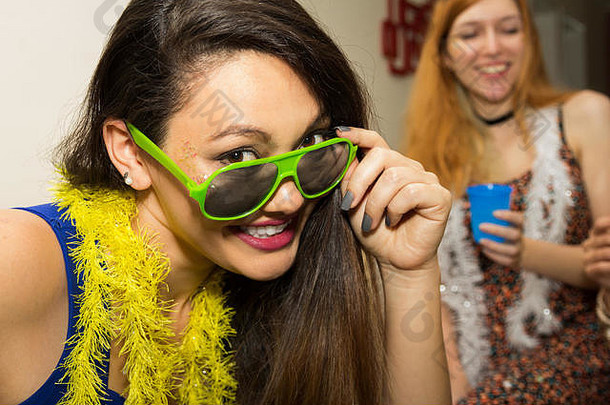 漂亮的亚洲女人穿绿色太阳镜黄色的围巾狂欢节聚会，派对巴西快乐头拍摄微笑朋友