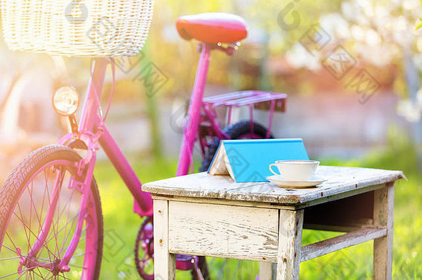 杯茶书粉红色的自行车白色篮子野餐场景绿色草花园