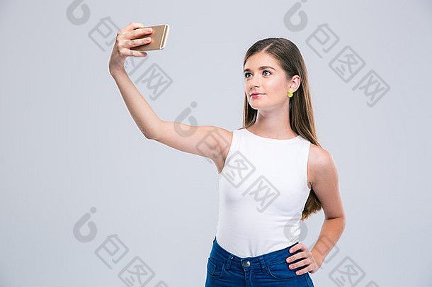 肖像快乐女少年使自拍照片智能手机孤立的白色背景