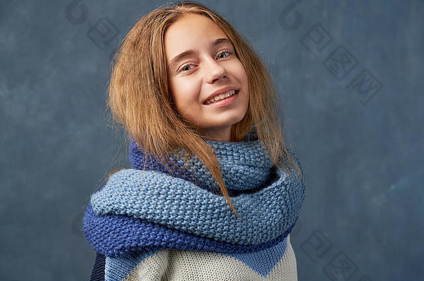 十几岁的女孩金发女郎温暖的毛衣孤立的墙