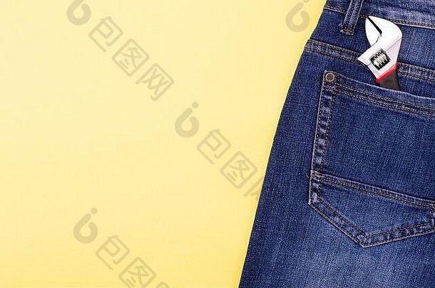 扳手工匠牛仔裤口袋里黄色的背景的地方文本