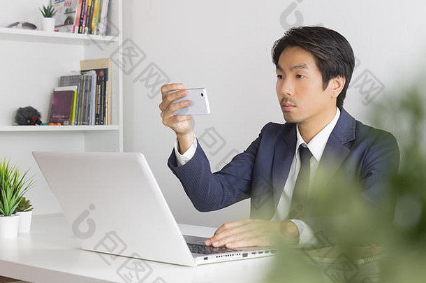 亚洲商人照片自拍智能手机前面移动PC监控办公室亚洲商人放松时间