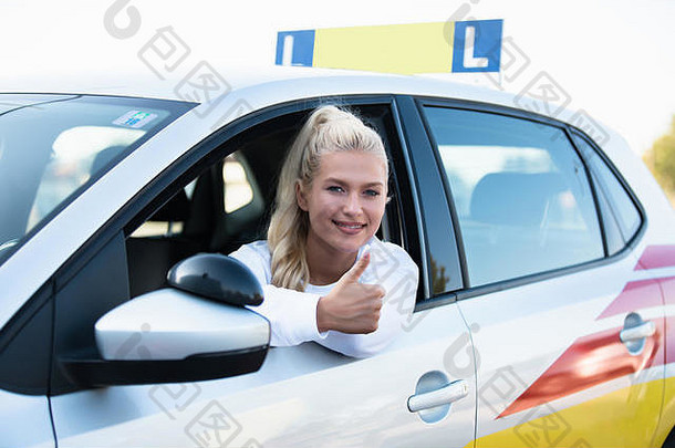 开车学校女年轻的车司机拇指通过开车许可证测试成功的女人微笑车辆免费的空间