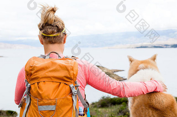 女人徒步旅行秋田犬犬儒狗海山视图娱乐健康的生活方式在户外夏天自然