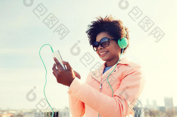 快乐年轻的女人智能手机耳机