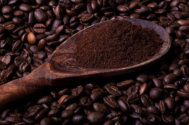 木勺子完整的咖啡粉背景使咖啡豆子