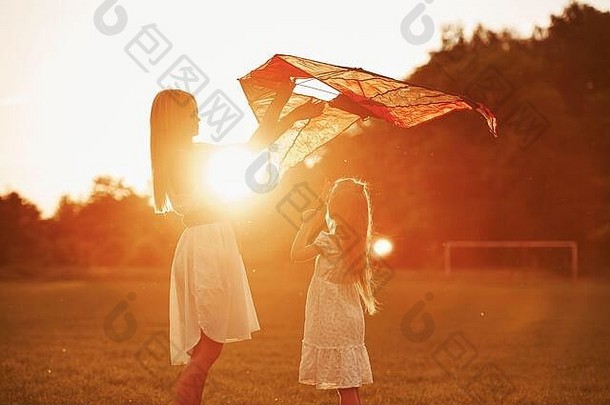 橙色彩色的日落妈妈。女儿有趣的<strong>风筝</strong>场美丽的自然