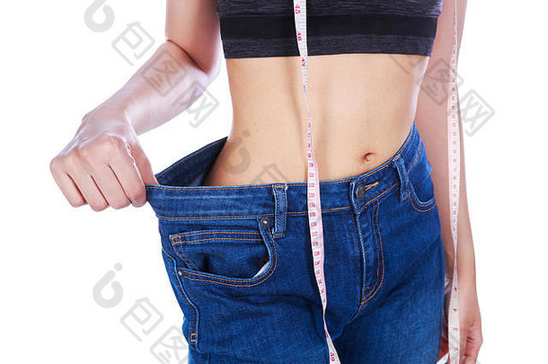 关闭重量损失女人穿牛仔裤测量磁带孤立的白色背景