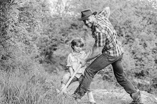 可爱的孩子自然有趣的牛仔爸爸找到珍宝男孩父亲铲珍宝快乐童年冒险狩猎珍宝助手花园