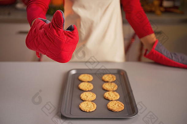 特写镜头年轻的家庭主妇厨房手套显示拇指圣诞节饼<strong>干锅</strong>