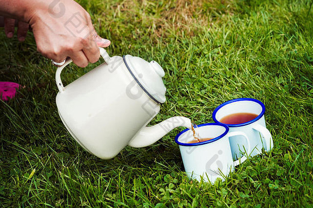 女人倒茶能杯子草坪上
