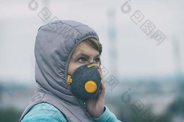 女人穿真正的反污染的anti-smog病毒脸面具密集的烟雾空气