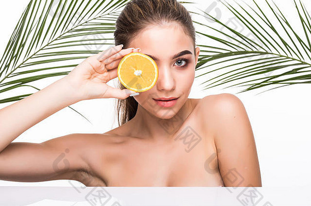 美丽的年轻的女人柑橘类水果棕榈叶子白色背景
