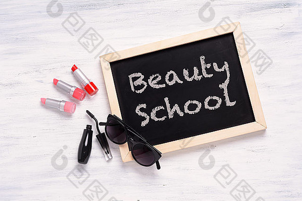 黑板美学校写化妆品产品白色木背景时尚化妆概念