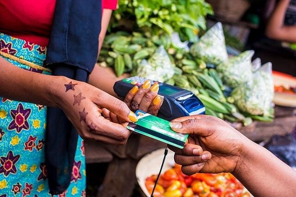 关闭非洲女人销售当地的非洲市场持有移动点出售设备收集信贷卡客户