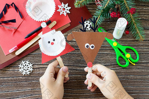 孩子持有圣诞节圣诞老人驯鹿股份木偶手工制作的项目孩子们的创造力手工艺品工艺品孩子们