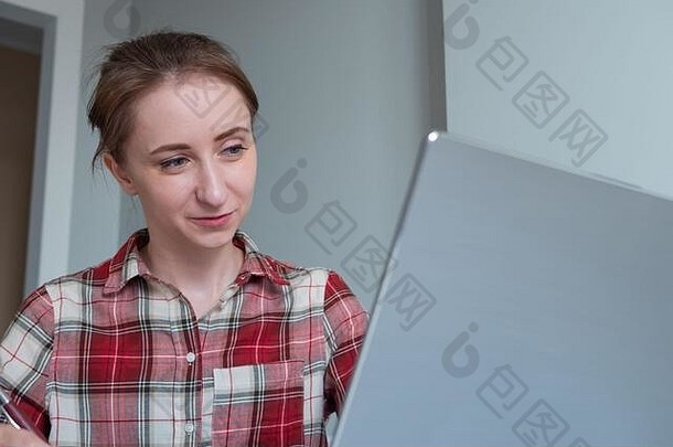 女人红色的格子衬衫微笑显示移动PC电脑房间灰色墙首页工作场所休闲时间教育