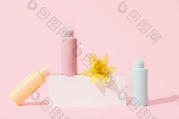 多彩色的容器化妆品瓶花空空白品牌自然美产品概念粉红色的背景