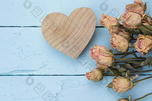 自然木雕刻心干粉红色的玫瑰关闭蓝色的画木木板背景