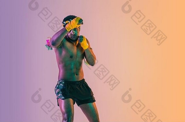 泰拳泰国年轻的男人。锻炼泰国拳击梯度背景霓虹灯光战斗机练习培训武术艺术行动运动健康的生活方式体育运动亚洲文化概念