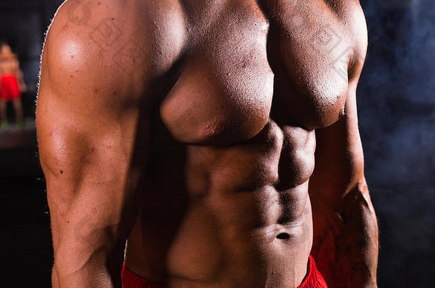 肌肉发达的健美运动员健身房显示ABS
