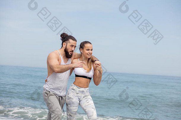 快乐高加索人运动型夫妇走海滩
