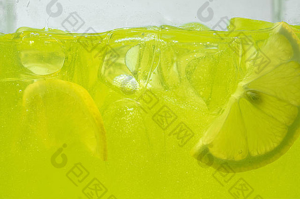 关闭视图柠檬片柠檬水背景纹理冷却甜蜜的夏天的喝宏泡沫玻璃墙嘶嘶声浮动前表面