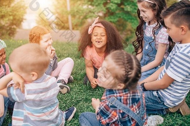 友谊童年休闲人概念集团快乐孩子们朋友坐着草夏天公园