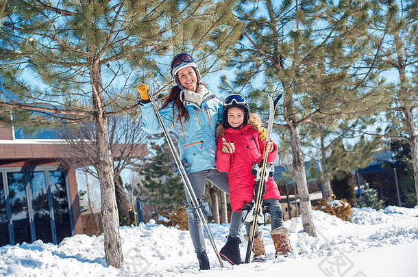 冬天假期家庭时间在户外女人女孩护目镜滑雪板摆姿势显示图姆微笑快乐的