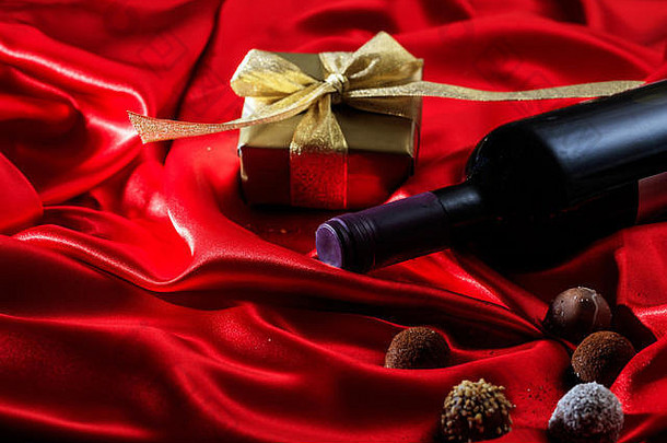 情人节一天概念红色的酒瓶巧克力礼物盒子红色的丝绸纺织
