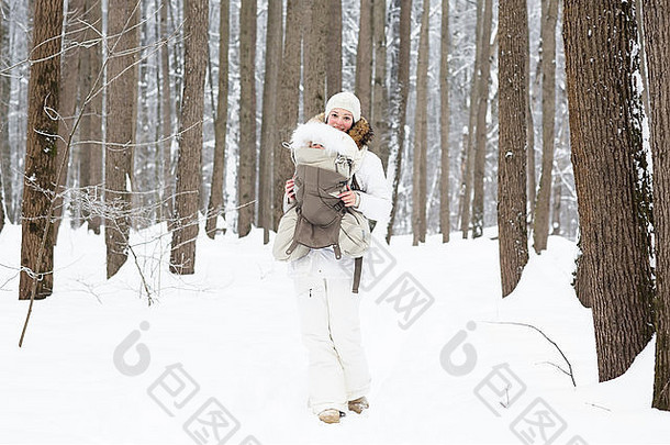 年轻的妈妈。携带婴儿森林雪一天