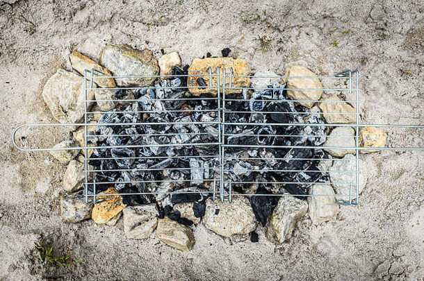 自制的简易烧烤烧烤烧烤桑迪海滩假期使煤炭火加工成烧烤烧烤沙子岩石石头