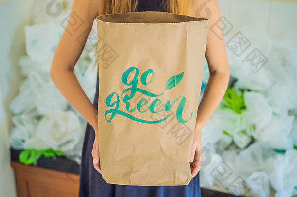 女人持有包登记绿色在桩塑料袋浪费概念概念世界环境一天