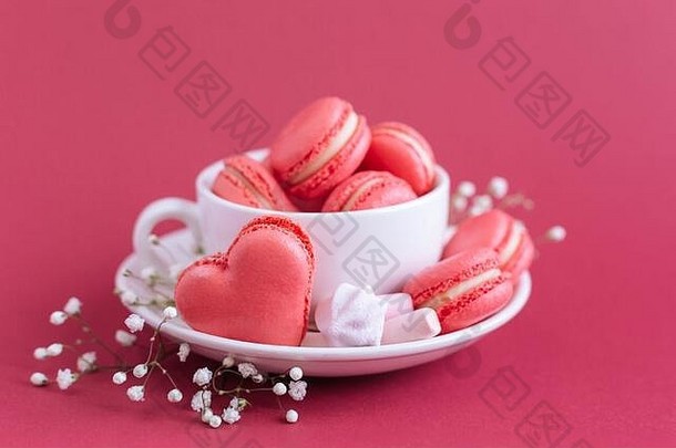 情人节一天背景粉红色的法国心形的马卡龙棉花糖杯马卡龙棉花糖