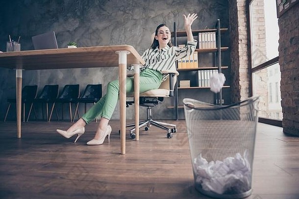 完整的大小照片积极的快乐的工人市场营销人员女孩工作感觉有趣的扔皱巴巴的纸垃圾本坐椅子现代阁楼办公室