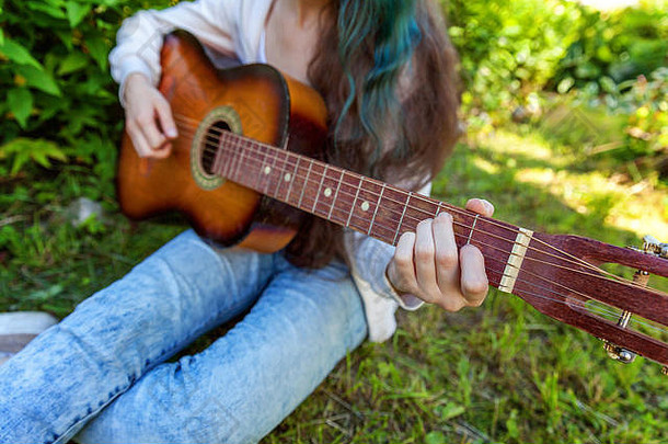 特写镜头女人手玩声吉他公园花园背景青少年女孩学习玩首歌写作音乐爱好生活方式放松仪器休闲教育概念