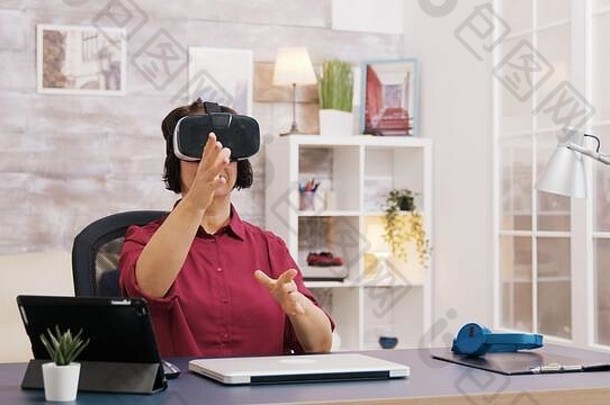上了年纪的年龄女人虚拟现实护目镜生活房间男人。坐着沙发背景