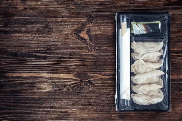 前视图日本饺子包装塑料托盘黑暗木表格概念东方快食物复制空间文本