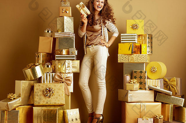 完整的长度肖像微笑年轻的时尚迷黄金米色衣服礼物盒子桩金礼物前面平原墙月!